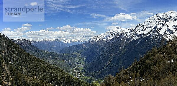 Beautiful top view panorama of high snow-covered mountains and valley with road and village in Switzerland at spring