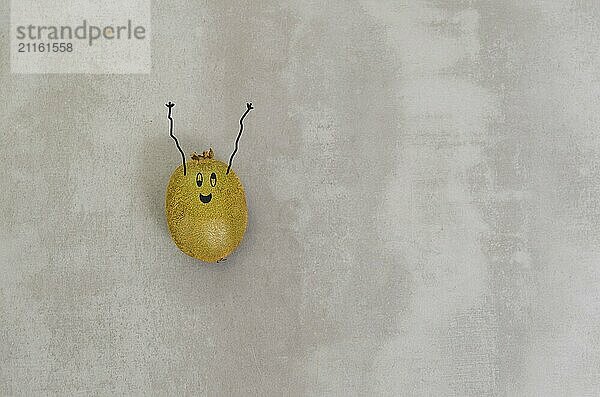 Great concept of healthy eating  kiwi with happy face and arms upwards in gray background