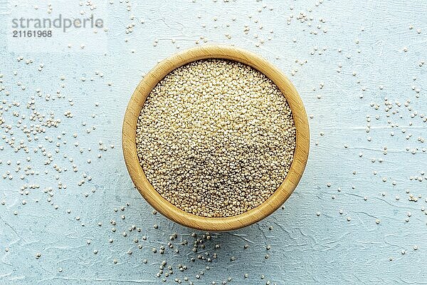 Quinoa in einer Schüssel  gesundes Bio Holz  ungekocht  Aufnahme von oben auf blauem Hintergrund  Foodfotografie