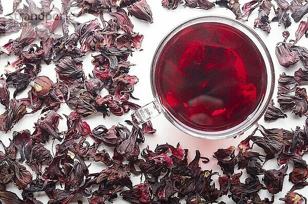 Top view of Hibiscus Tea cup with petals aside on white background