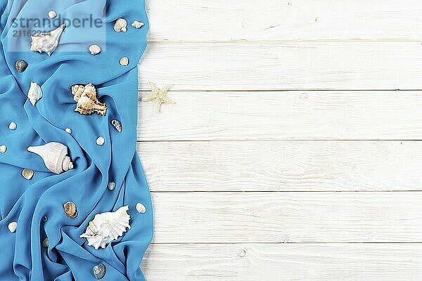 Seashells  blue fabric and starfish on white planks vacation planning background flat lay with copy-space