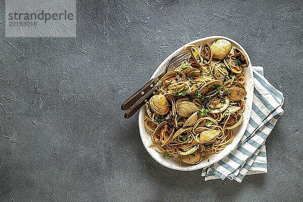 Food  Food  Seafood Pasta. ITALIAN SPAGHETTI ALLE VONGOLE. Clams spaghetti on white plate with white wine  gray background. Top view