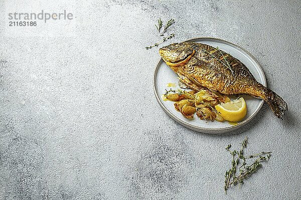 Food  Grilled sea bream or dorada on gray plate. Gray background