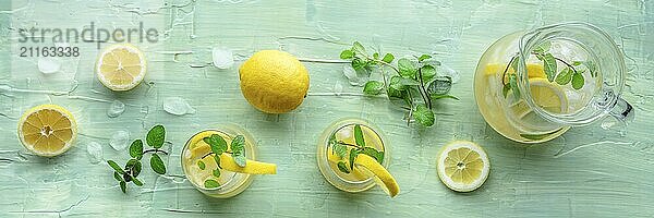 Limonade mit Minze Panorama. Zitronenwasser Getränk mit Eis. Zwei Gläser und ein Krug auf einem blauen Hintergrund  Overhead Flat Lay Schuss. Detox Getränk. Frischer hausgemachter Cocktail  Food Fotografie