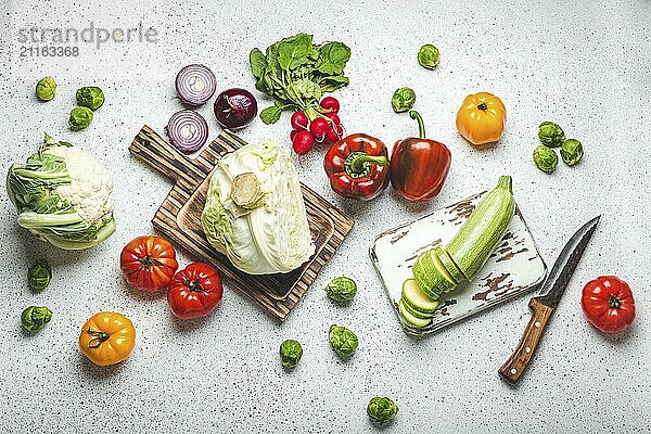 Frische verschiedene Gemüse mit hölzernen Schneidebretter und Messer auf weißen Küchentisch Draufsicht. Kochen vegetarische Mahlzeit aus gesunden Zutaten  Diät Lebensmittel und Ernährung Konzept  Lebensmittel Fotografie