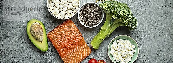 Auswahl an gesunden Lebensmitteln  wenn eine Person Diabetes hat: Lachs  Fisch  Brokkoli  Avocado  Bohnen  Gemüse  Samen auf grauem Hintergrund von oben. Gesunde Diabetes Diät  Lebensmittel Fotografie  food photography