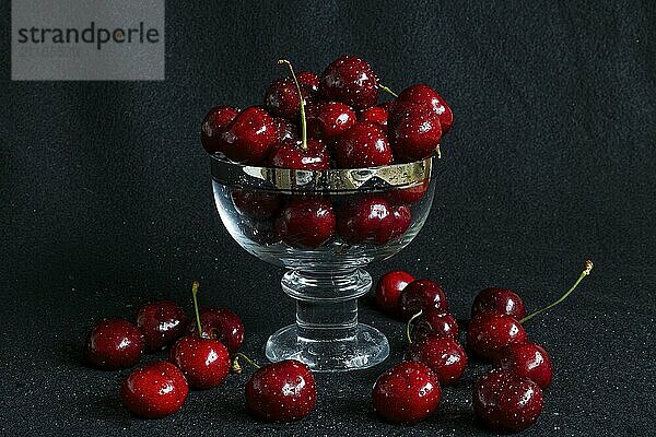 Fruits  red cherries in a glass against dark background  Province of Quebec  Canada  North America