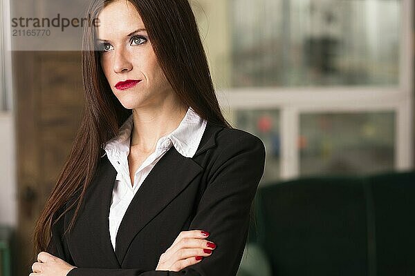 Beautiful young adult woman looks right at camera in the office