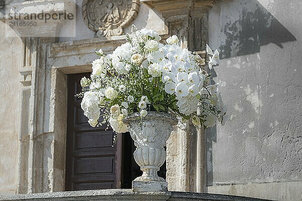 Romantic wedding bouquet in a baroque stone vase in front of the Chiesa di San Giuseppe in Taormina in Sicily  Italy  Europe