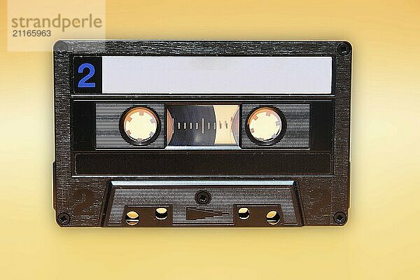 Retro audio cassette tape on yellow background. Front view of side two and traces of dust with minor scratches