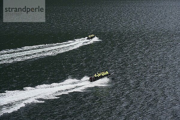 Two speedboats with groups of people travelling fast in the Geiranger Fjord  white waves are coming up behind them  Geiranger  Geiranger Fjord  Stranda  Romsdal  Norway  Europe