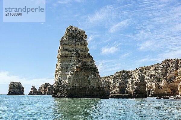 Majestätische Felsformationen in Lagos  Portugal  erheben sich aus dem ruhigen Wasser des Ozeans vor einem klaren blauen Himmel. Die heitere Küstenlandschaft ruft Gefühle von Frieden und Ehrfurcht hervor. Ideal für Natur und Reisethemen  Europa