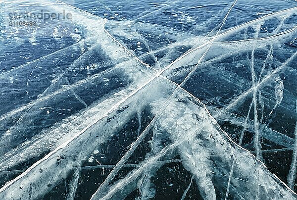 Frozen Lake Baikal background. Blue transparent clear smooth ice with deep cracks. Famous natural landmark of Russia