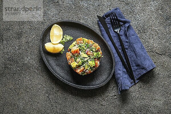 Food  Food  PERUVIAN NIKKEI FOOD. Salmon avocado ceviche on black plate  black background top view