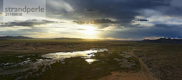 Aerial panorama of the sand dunes Elsen Tasarhai (Bayan Gobi) and lake at sunset in Mongolia