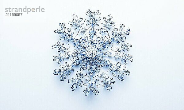 A snowflake made of blue glass is on a white background. The snowflake is made of many small pieces of glass  and it looks like it is made of ice. The blue color of the snowflake gives it a cool AI generated