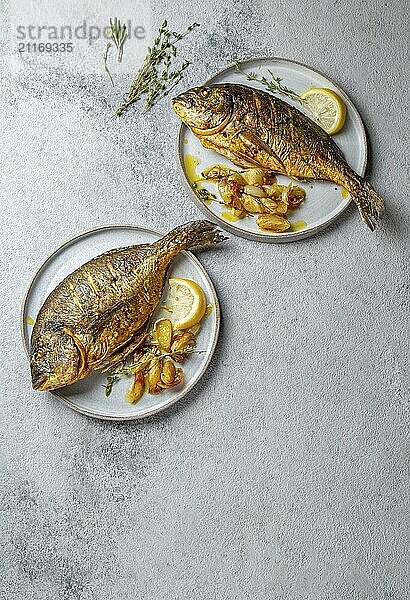 Food  Grilled sea bream or dorada on gray plate. Gray background