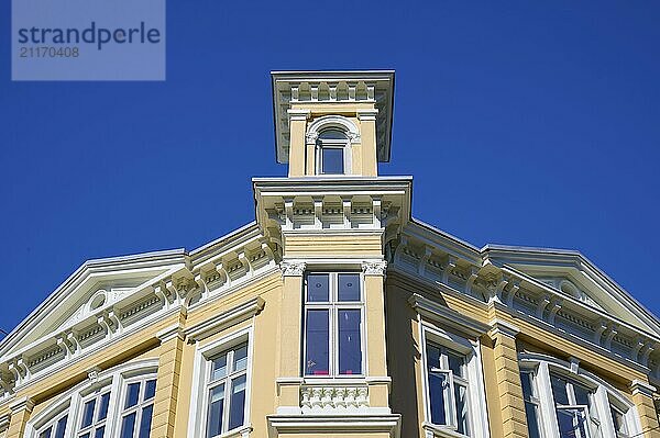 Historic yellow building with several windows in front of a bright blue sky  Bergen  Vestland  Norway  Europe