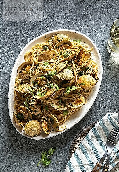 Food  Food  Seafood Pasta. ITALIAN SPAGHETTI ALLE VONGOLE. Clams spaghetti on white plate with white wine  gray background. Top view