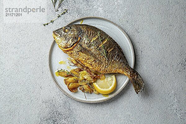 Food  Food  Grilled sea bream or dorada on gray plate. Gray background