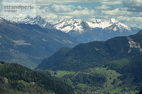 Beautiful aerial view of high snow-covered mountains and valley with village in Switzerland