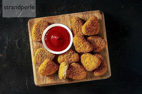 Chicken Nuggets auf schwarzem Hintergrund  Overhead Flachbildaufnahme. Eine knusprige Vorspeise in einem Restaurant  ein Fast Food Gericht  Food Fotografie