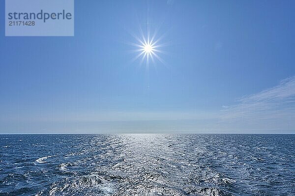 Clear sea under a bright sun and blue sky  calm atmosphere with a wide horizon  North Sea  Norway  Europe