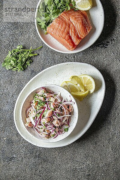 Food  Food  CHILEAN SALMON CEVICHE. Fresh raw salmon marinaded with purple onion  coriander in lemon juice. Sebiche and ingredientes on gray background. Top view