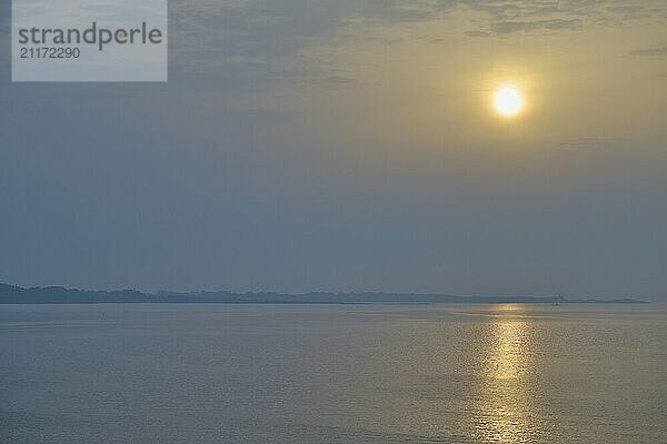 Sunset at the calm sea with yellow light and blue sky  peaceful evening mood  Bergen  North Sea  Norway  Europe