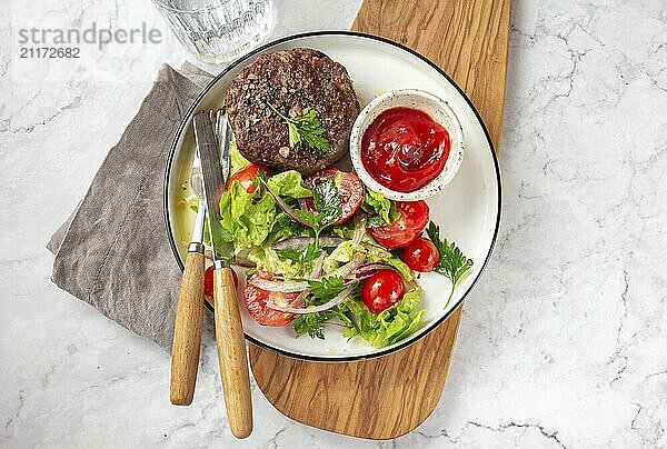 Food Photography  Beef hamburger with lettuce tomato salad on white plate  top view