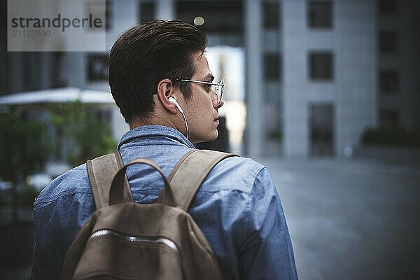 Portrait of handsome successful businessman walking on the street and thinking about startup project