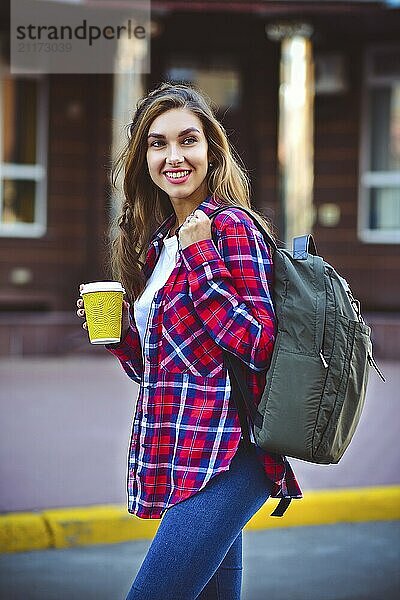 Beautiful girl walking on the street with coffee