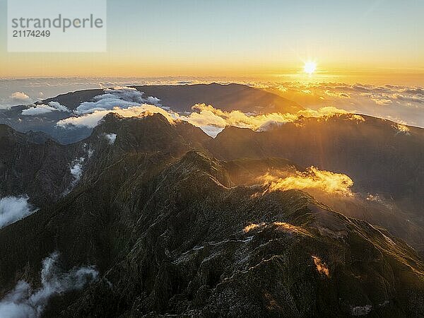 Aerial drone view of mountains over clouds near Pico Ruivo on sunset. Madeira island  Portugal  Europe