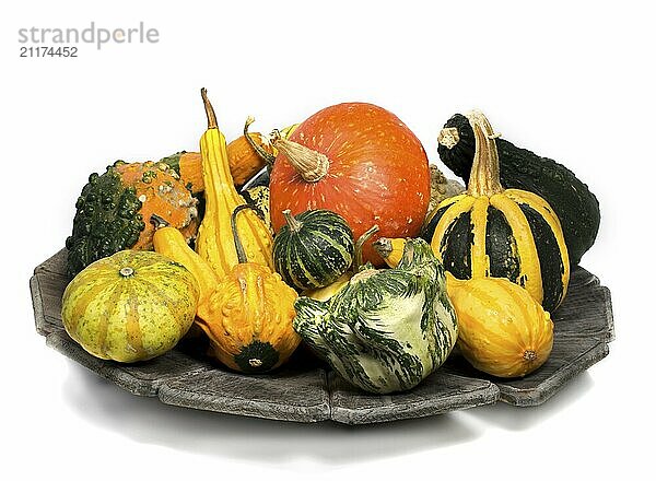 Wooden plate with decoration vegetables in red and green isolated on white