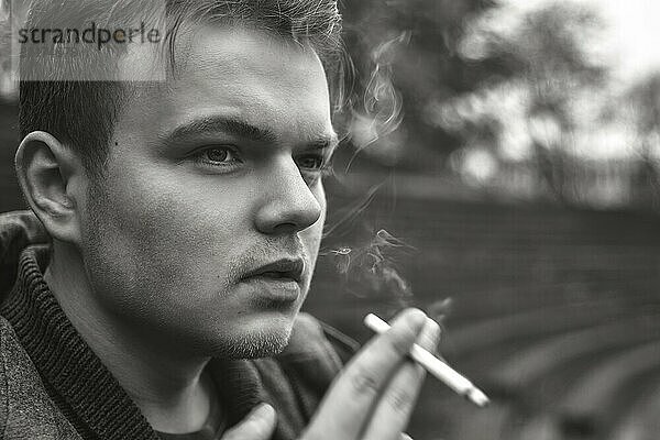 Guy smokes a cigarette outside  portrait  close-up