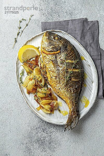 Food  Food  Grilled sea bream or dorada on gray plate. Gray background