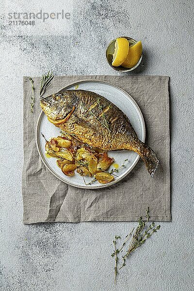 Food  Food  Grilled sea bream or dorada on gray plate. Gray background