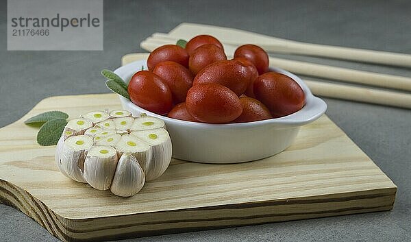 Wooden board with cherry tomatoes on gray background. culinary background