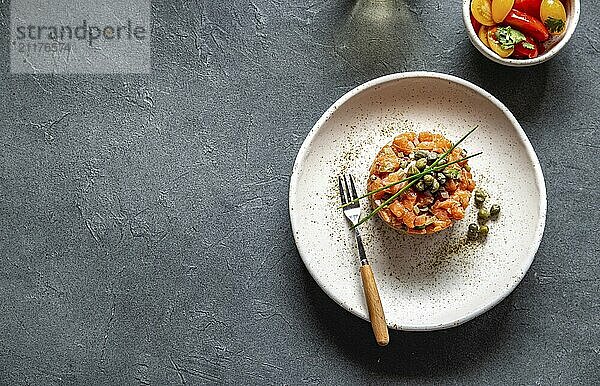 Food  Food  SALMON TARTAR with capers and purple onion on white plate  gray background