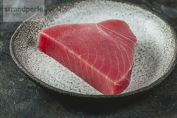 Food  Raw fresh TUNA STEK on gray plate. Black background