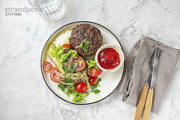 Food  Beef hamburger with lettuce tomato salad on white plate  top view