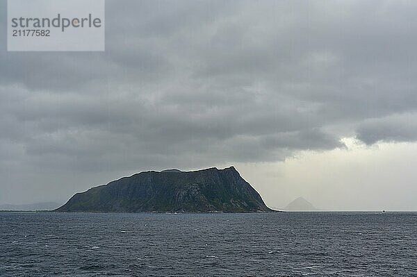 An island in the sea under a cloudy  gloomy sky  Alesund  Fylke  Norway  Europe