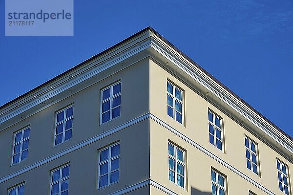 A pink corner building with many windows against a clear blue sky  Bergen  Vestland  Norway  Europe