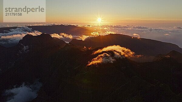 Luftaufnahme vom Fliegen am Pico Ruivo von Bergen mit Wolken bei Sonnenuntergang. Insel Madeira  Portugal. Orbit Parallaxe Schuss