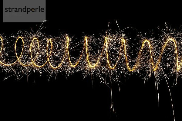 Spiral lights with sparks on a black background. Christmas lights on a long exposure