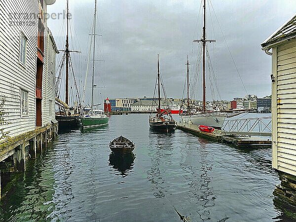 Quiet harbour scene with several boats and wooden buildings on a cloudy day  Alesund  Fylke  Norway  Europe