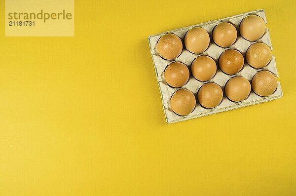 Beautiful fresh brown chicken eggs on yellow background with copy space