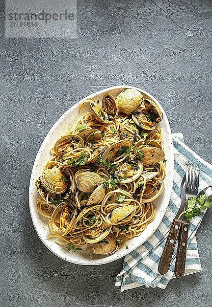 Food  Food  Seafood Pasta. ITALIAN SPAGHETTI ALLE VONGOLE. Clams spaghetti on white plate with white wine  gray background. Top view