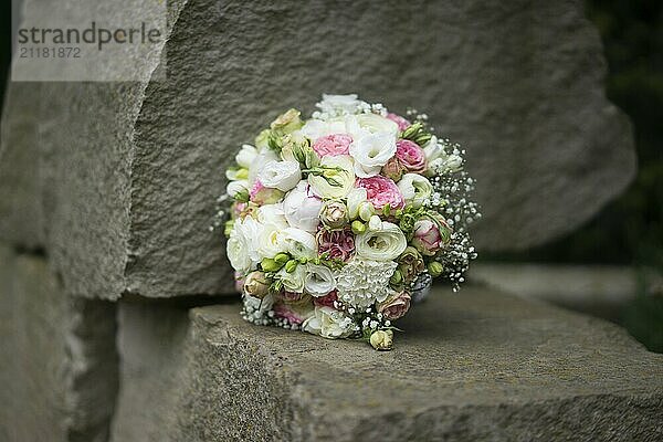 A bridal bouquet lying on a stone