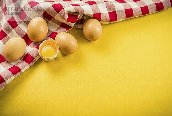 Beautiful fresh brown chicken eggs on yellow background with copy space